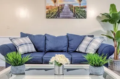 a blue couch with two pillows on a table at Premier League Pad in Manchester