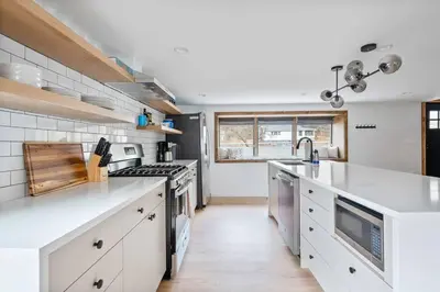 a large kitchen with white counter tops and a sink at Chateau Bungalow - Ski Belleayre, Hunter in Shandaken