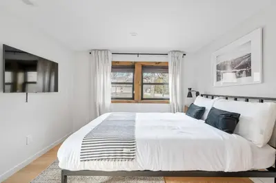 a white bedroom with a large bed and a window at Chateau Bungalow - Ski Belleayre, Hunter in Shandaken