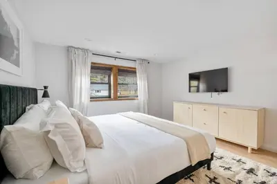 a white bedroom with a bed and a television at Chateau Bungalow - Ski Belleayre, Hunter in Shandaken