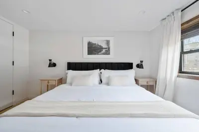 a white bedroom with a large bed with white sheets at Chateau Bungalow - Ski Belleayre, Hunter in Shandaken