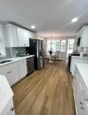 a kitchen with white cabinets and a wooden floor at Modern 4BDRM West Hartford Home In Great Location! in West Hartford