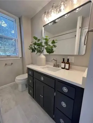 a bathroom with a sink and a mirror and a toilet at Modern 4BDRM West Hartford Home In Great Location! in West Hartford