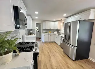 a kitchen with white cabinets and a stainless steel refrigerator at Modern 4BDRM West Hartford Home In Great Location! in West Hartford