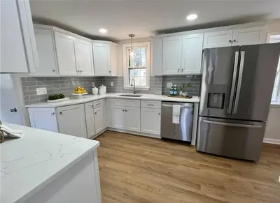 a kitchen with white cabinets and a stainless steel refrigerator at Modern 4BDRM West Hartford Home In Great Location! in West Hartford