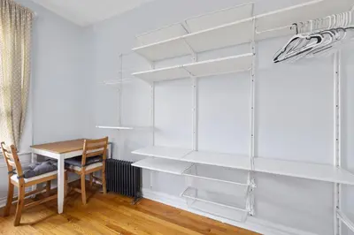 a dining room with white shelves and a table at Live Upper Manhattan on a Budget in New York