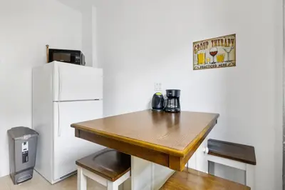 a kitchen with a wooden table next to a refrigerator at Live Upper Manhattan on a Budget in New York
