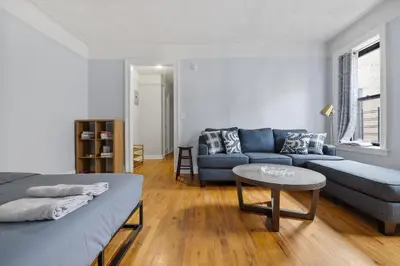 a living room with a bed and a couch at Live Upper Manhattan on a Budget in New York