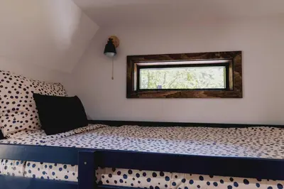 a bedroom with a bed with a cheetah patterned sheets and a window at Emberwood Lodge - Luxury Cabin, Kid Friendly in Catskill