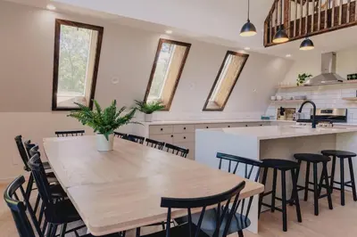 a large kitchen with a wooden table and chairs at Emberwood Lodge - Luxury Cabin, Kid Friendly in Catskill