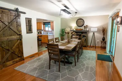 a dining room with a table and chairs and a barn door at Serenity Falls - Stylish 4Bdr Mountain Retreat, Hot Tub, Pool in East Stroudsburg