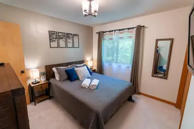 a bedroom with a bed with two towels on it at Serenity Falls - Stylish 4Bdr Mountain Retreat, Hot Tub, Pool in East Stroudsburg