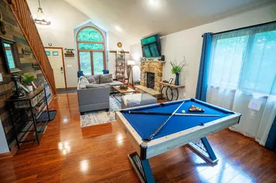a pool table in the middle of a living room at Harmony Hill Stylish 4bd Mountain Retreat, Hot Tub, Games in Bushkill