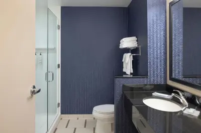 a bathroom with blue walls and a toilet and a sink at Fairfield Inn & Suites by Marriott Springfield Northampton/Amherst in Northampton