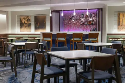 a restaurant with tables and chairs and a bar at Fairfield Inn & Suites by Marriott Springfield Northampton/Amherst in Northampton