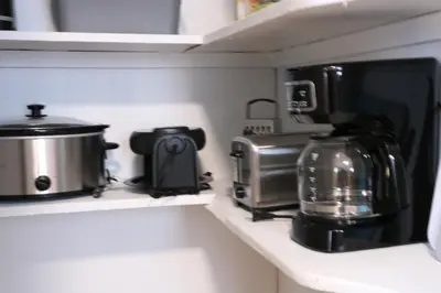 a kitchen counter with a coffee maker and a toaster at 4 bedroom short term rental furnished Apt in Schenectady