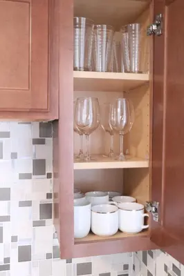 a cupboard with wine glasses and plates and bowls at 4 bedroom short term rental furnished Apt in Schenectady
