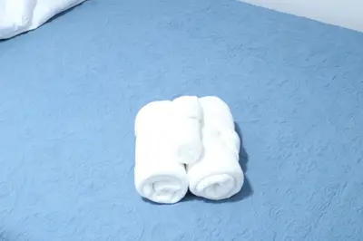 two white towels sitting on top of a bed at 4 bedroom short term rental furnished Apt in Schenectady