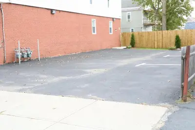 an empty parking lot next to a red brick building at 4 bedroom short term rental furnished Apt in Schenectady