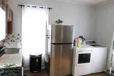 a kitchen with a refrigerator and a microwave at 4 bedroom short term rental furnished Apt in Schenectady