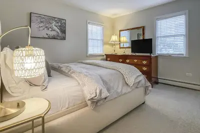 a bedroom with a bed and a dresser and a tv at Candlewood Lake House in Danbury