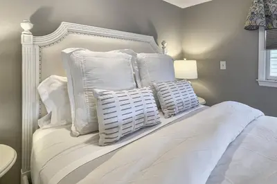 a white bed with white pillows on top of it at Candlewood Lake House in Danbury