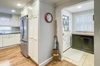 a kitchen with a refrigerator and a clock on the wall at Candlewood Lake House in Danbury