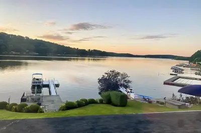 a dock on a lake with a boat in the water at Candlewood Lake House in Danbury
