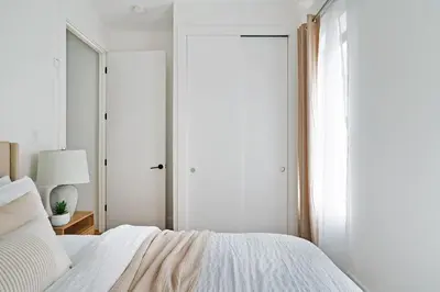 a white bedroom with a bed and a window at 1290-13 Newly Renovated 2 Bedrooms in UES in New York