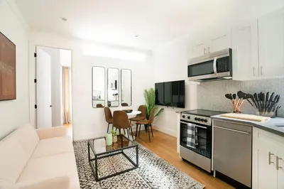 a kitchen and living room with a stove top oven at 1290-13 Newly Renovated 2 Bedrooms in UES in New York