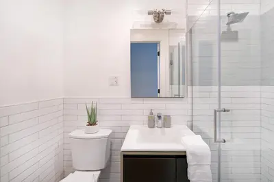 a white bathroom with a toilet and a sink at 1290-13 Newly Renovated 2 Bedrooms in UES in New York