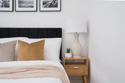 a bedroom with a bed and a table with a lamp at 1290-13 Newly Renovated 2 Bedrooms in UES in New York