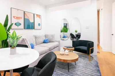 a living room with a couch and a table and chairs at 1290-6 Newly Renovated 2 Bedrooms in UES in New York