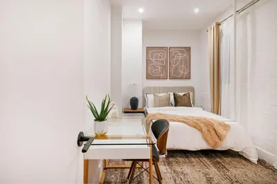 a white bedroom with a bed and a desk at 1290-6 Newly Renovated 2 Bedrooms in UES in New York