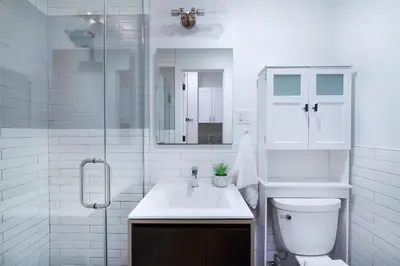 a white bathroom with a toilet and a sink at 1290-6 Newly Renovated 2 Bedrooms in UES in New York