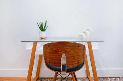 a desk with a wooden chair with a glass top at 1290-8 New Renovated 2 Bedrooms in UES in New York