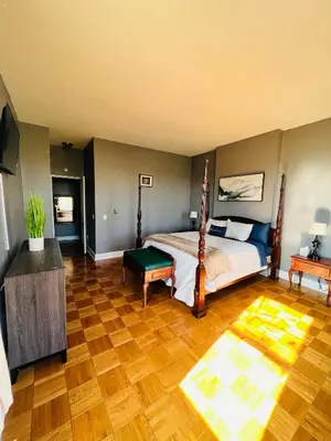 a bedroom with a bed and a wooden floor at Spacious Apartment Downtown Albany, NY in Albany