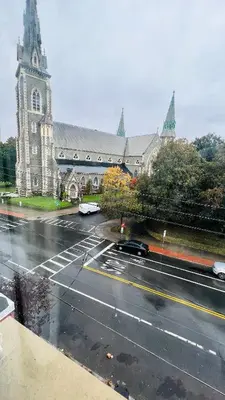 a church with a car parked in front of a street at Spacious Apartment Downtown Albany, NY in Albany