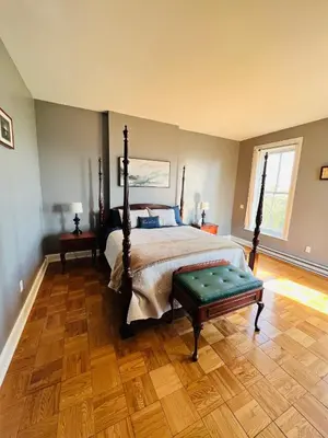 a bedroom with a bed and a wooden floor at Spacious Apartment Downtown Albany, NY in Albany
