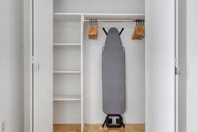 a tie hanging from a shelf in a closet at FiDi 2BR w Elevator Gym Doorman nr Wall St NYC-661 in New York