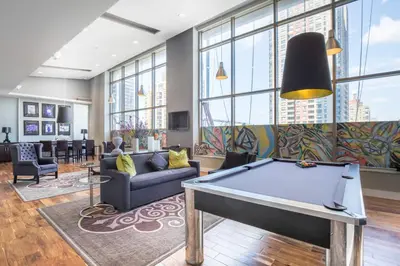 a pool table in a living room with windows at FiDi 2BR w Elevator Gym Doorman nr Wall St NYC-661 in New York