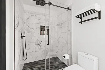 a bathroom with a shower with a glass door at Fire pit ~ Game Room ~ near NYC ~ Modern Luxury in New Rochelle