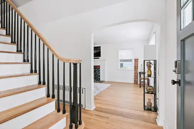 a staircase in a home with white walls and wood floors at Fire pit ~ Game Room ~ near NYC ~ Modern Luxury in New Rochelle