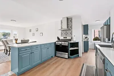 a kitchen with blue cabinets and a stove top oven at Fire pit ~ Game Room ~ near NYC ~ Modern Luxury in New Rochelle