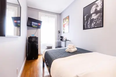 a bedroom with a bed with a teddy bear on it at The Central Park North in New York