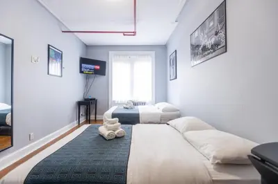 a bedroom with two beds and a tv in it at The Central Park North in New York