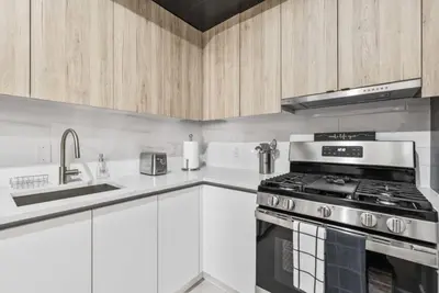 a kitchen with white cabinets and a stove top oven at Top Notch 2BR in Upper East Mins to Central Park in New York