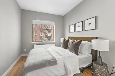 a bedroom with a large white bed and a window at Top Notch 2BR in Upper East Mins to Central Park in New York