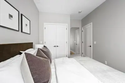 a bedroom with a bed with white sheets and pillows at Top Notch 2BR Suite Minutes to Central Park in New York