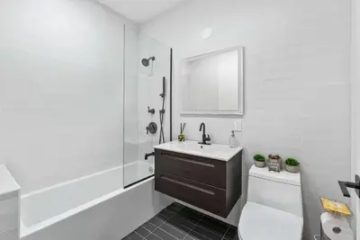 a bathroom with a sink and a toilet and a mirror at Top Notch 2 Bedroom Minutes From Central Park in New York
